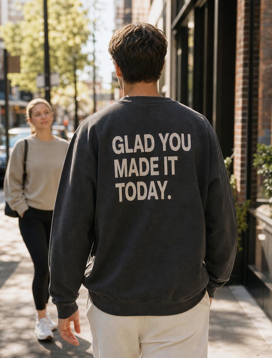 Person walking down a street with a printed message on the back of their sweatshirt being read by a passerby