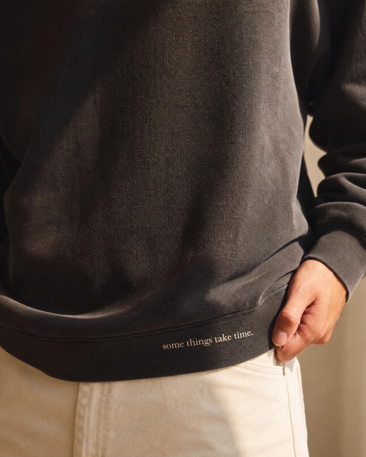 Close view of a printed line on a crewneck, worn by one person